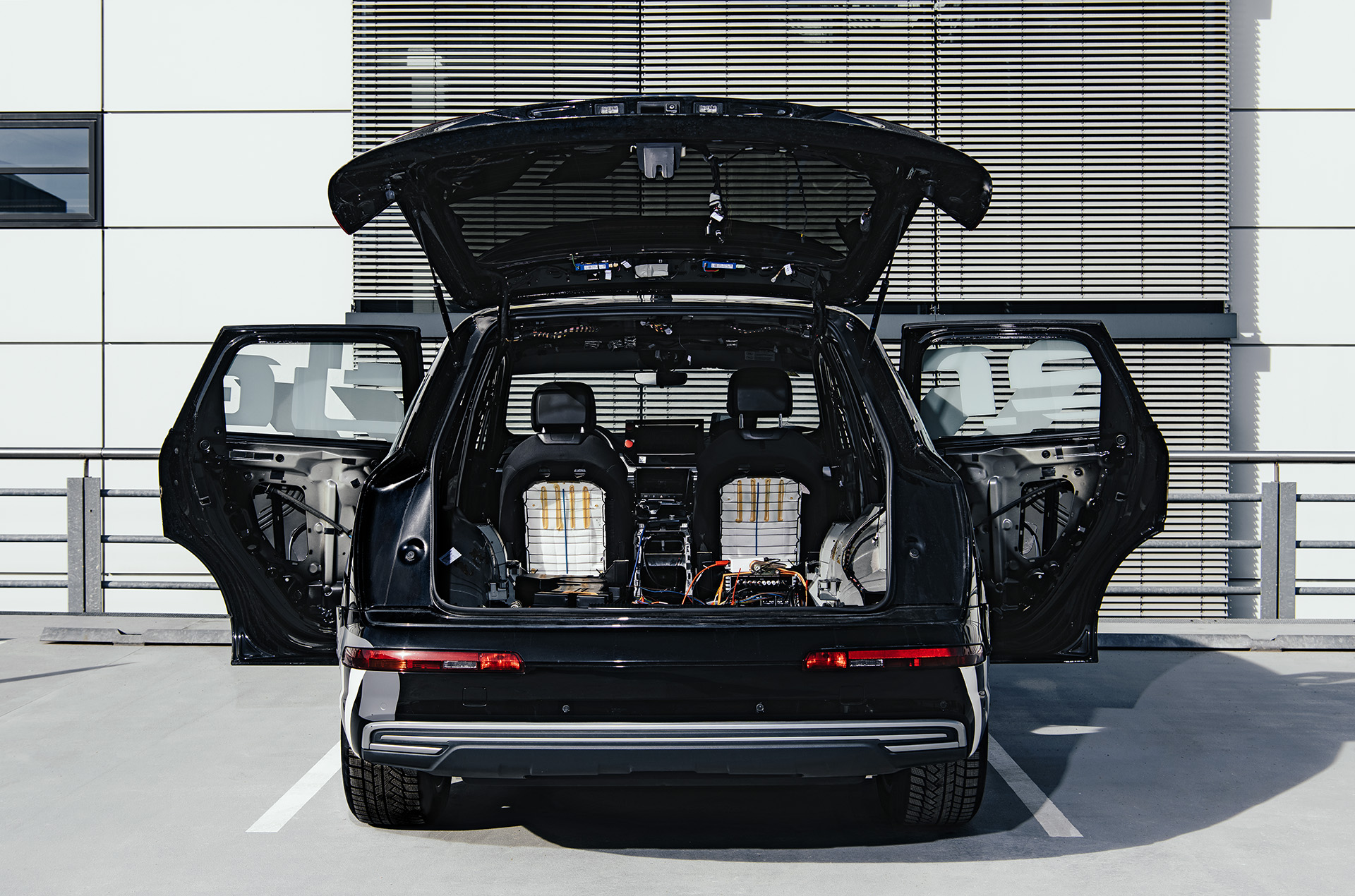 Een zicht vanaf de achterkant van de Brutus-conceptauto met de achterklep en zijdeuren open om de elektronica in de kofferbak en verwijderde binnenpanelen zichtbaar te maken.