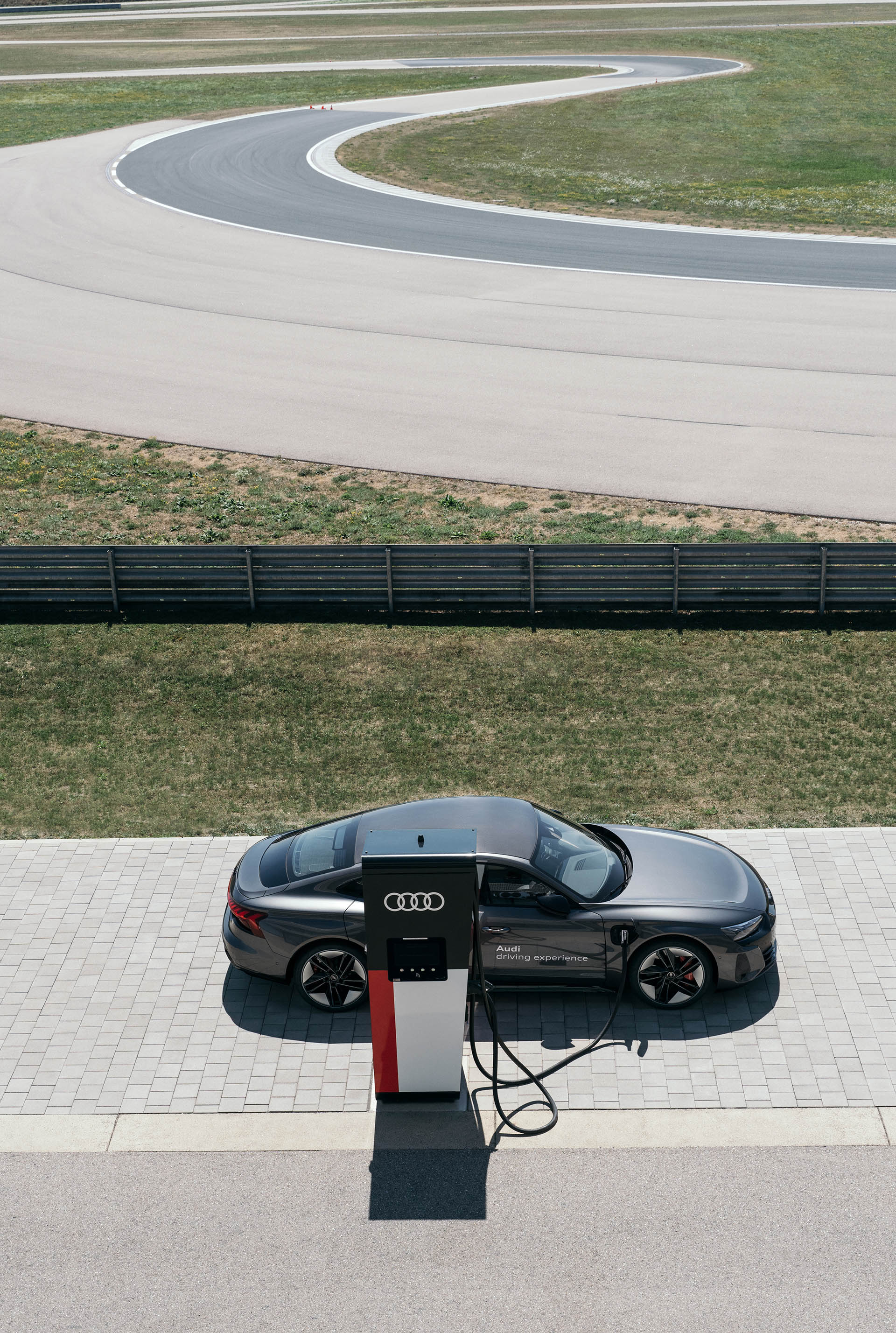 Een Audi RS e-tron GT van de Audi driving experience aan de lader bij het Audi-circuit.