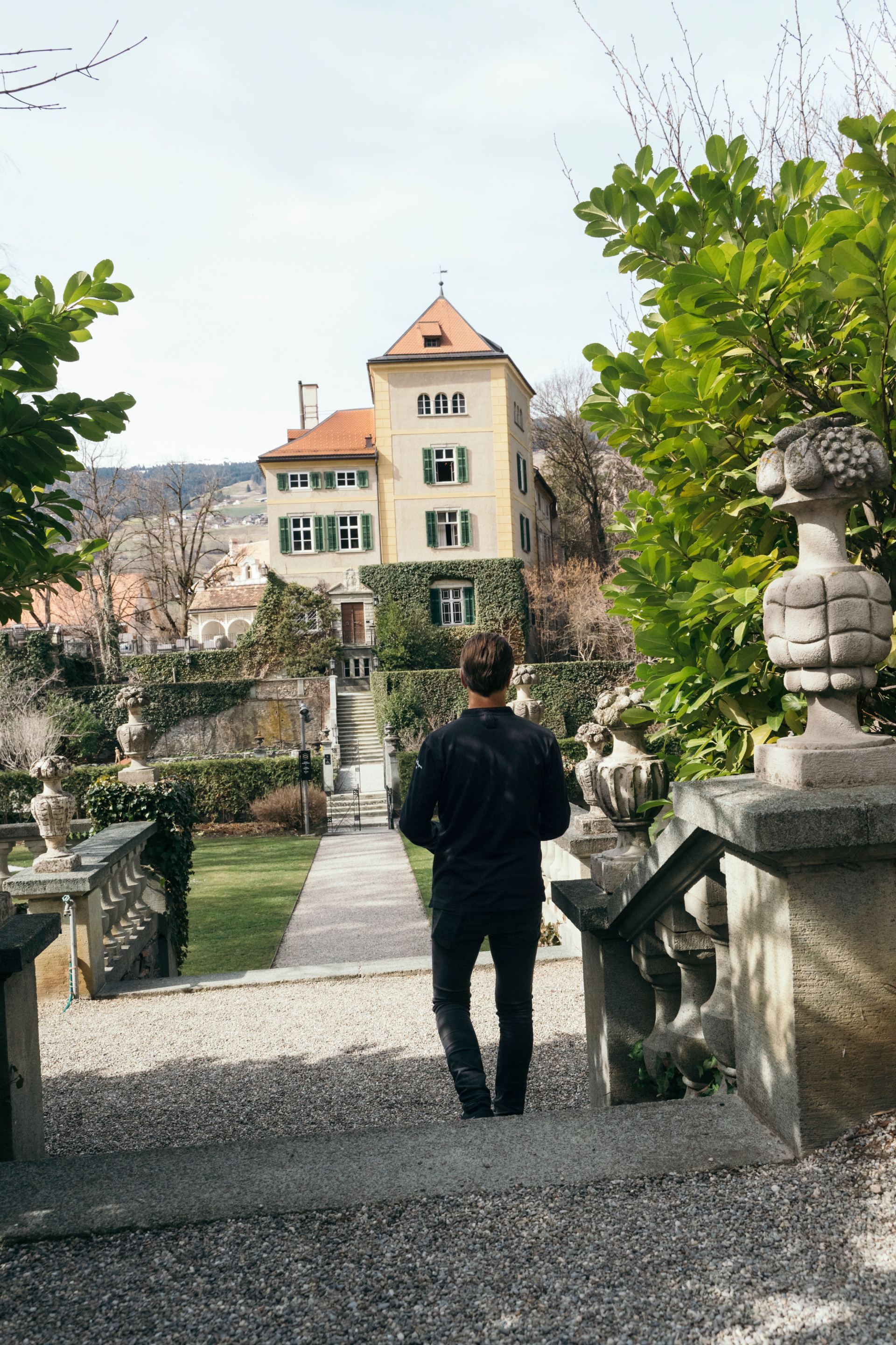 Andreas Caminada loopt de formele tuin in van Schloss Schauenstein.