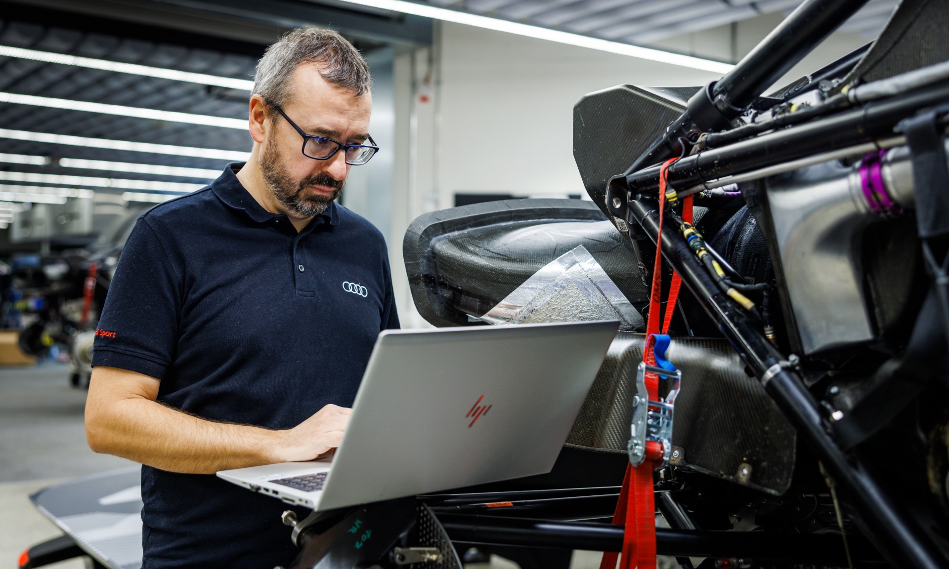 Arnau Nibuó met een laptop bij de Audi RS Q e-tron in opbouw.