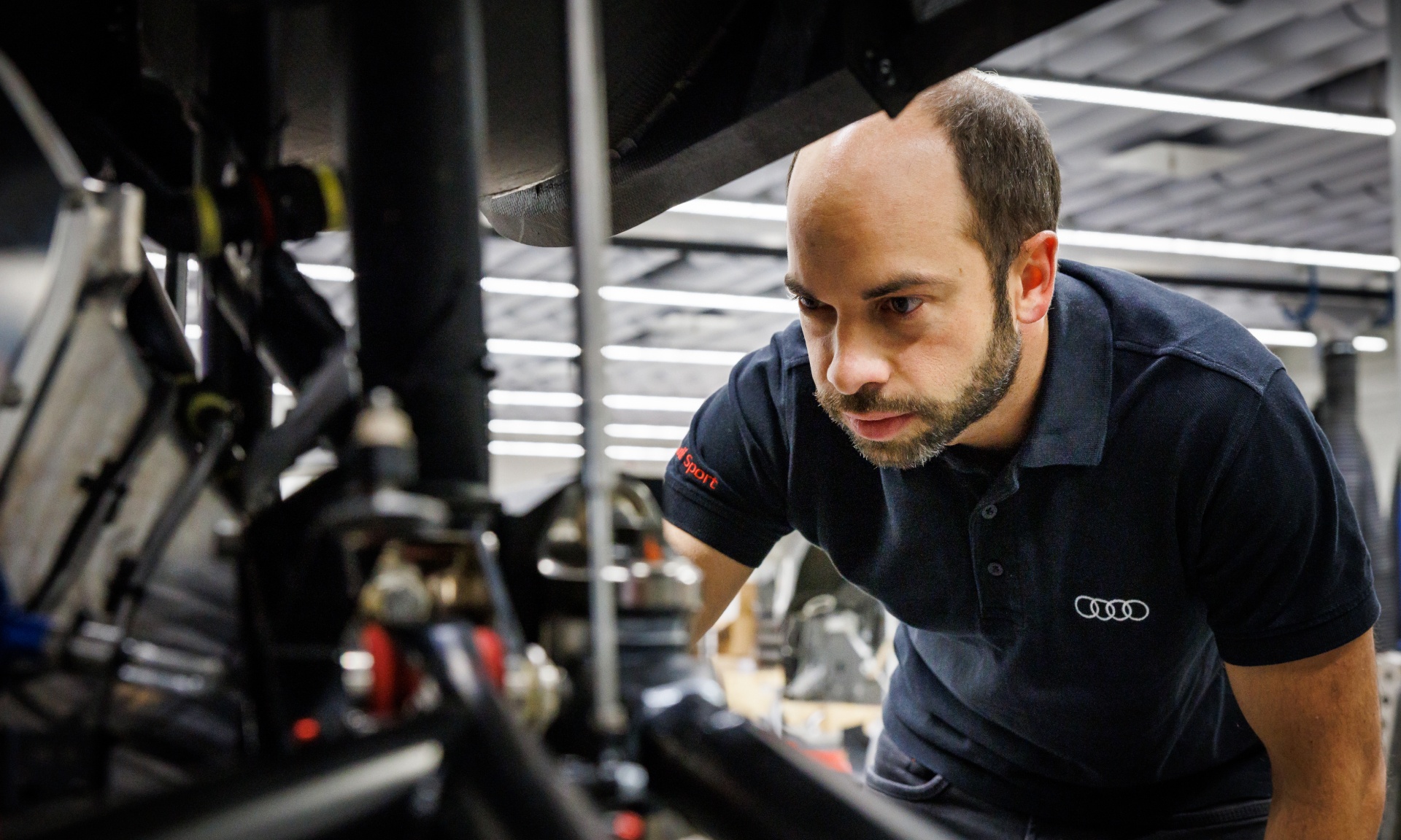 Benedikt Brunninger bekijkt een detail aan de gedemonteerde Audi RS Q e-tron.
