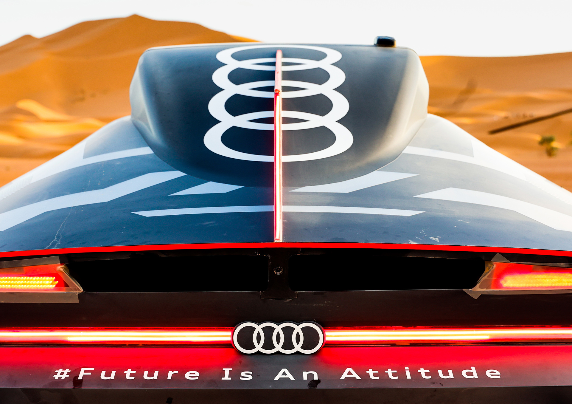 De achterkant van de Audi RS Q e-tron in de woestijn.